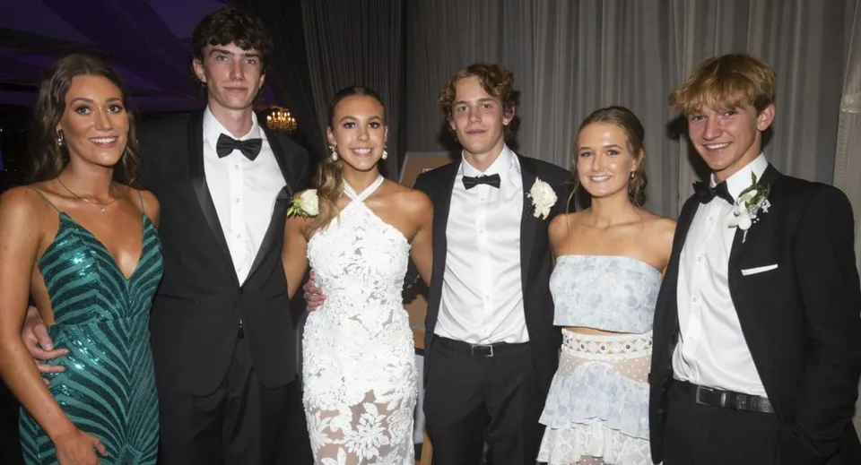 Un gruppo di persone ben vestite posa insieme a un evento formale della Villiers School.