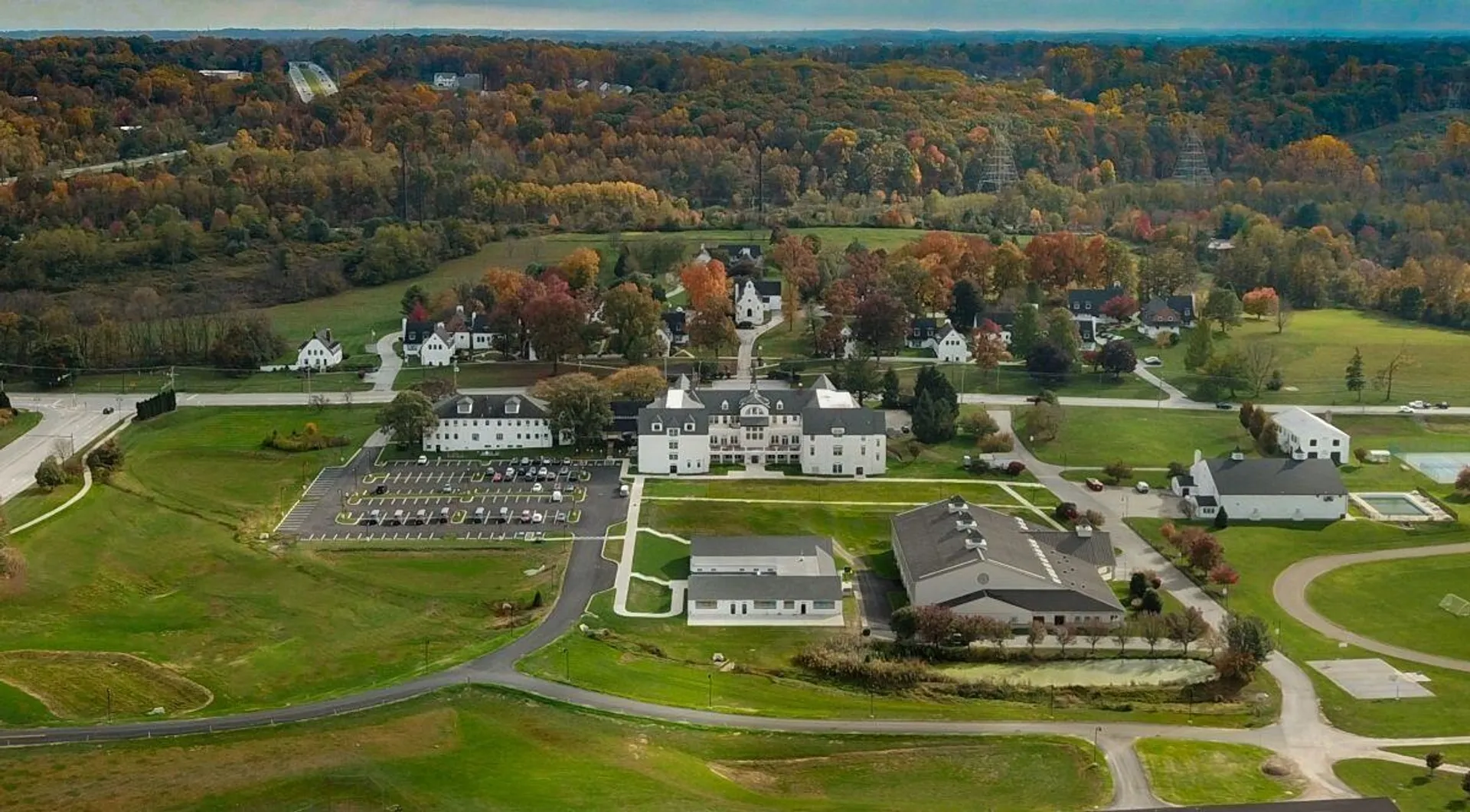 La Church Farm School mostra i suoi ampi edifici e i suoi giardini ben curati in un paesaggio autunnale.