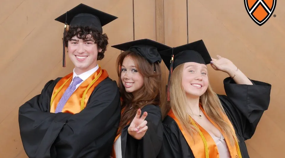Tre diplomati della TMI Episcopal School posano con tocco e toga da diploma davanti a una parete in legno con il logo della scuola.