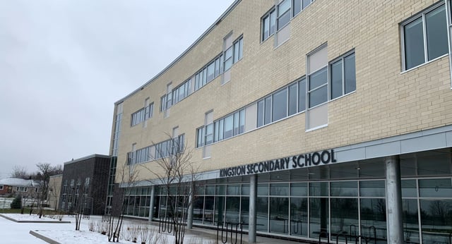 L'edificio in mattoni a più piani della Kingston Secondary School si erge davanti a un paesaggio innevato.