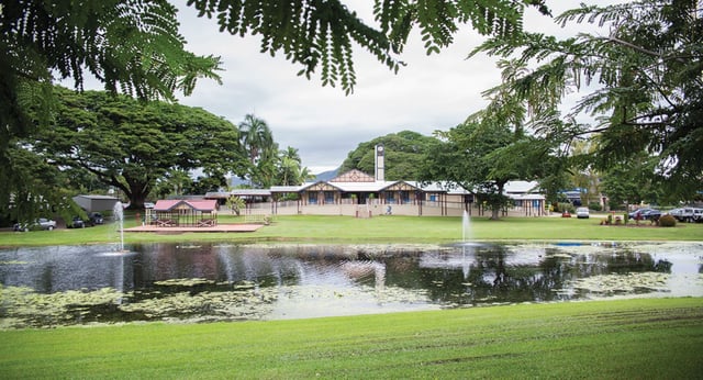 Ein grüner Park mit einem Teich und einer Holzhütte auf dem Gelände der Cathedral School of St Anne & St James.