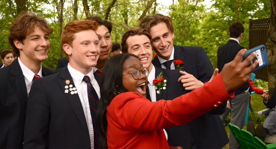 Un gruppo di studenti dello Stanstead College si fa un selfie insieme in un'area verde all'aperto.