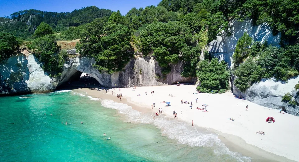 Un pittoresco paesaggio di spiaggia con scogliere e un'acqua limpida e turchese vicino al Birkenhead College.