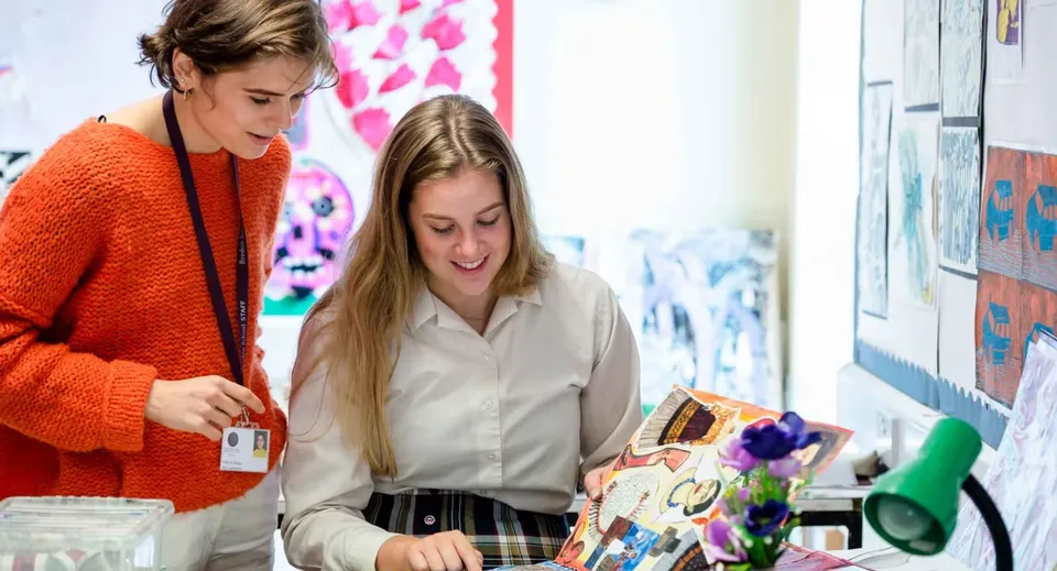 Due studentesse della Bredon School si trovano in una stanza con opere d'arte colorate sulle pareti.