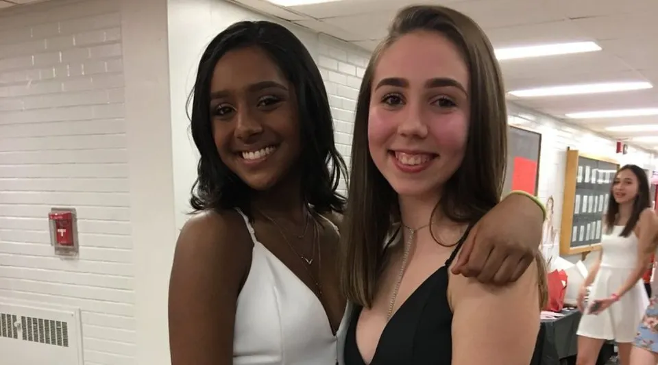 Due studentesse della Dunbarton High School sorridono insieme nel corridoio della scuola davanti agli armadietti.