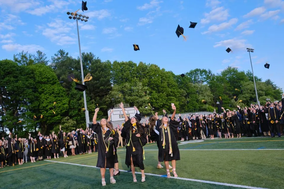 I diplomati della Bishop Fenwick High School lanciano i loro tocchi in aria sul campo sportivo.