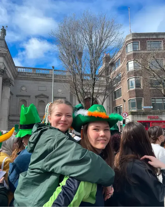 Due amiche si abbracciano con cappelli verdi durante il Saint Patrick's Day in Irlanda