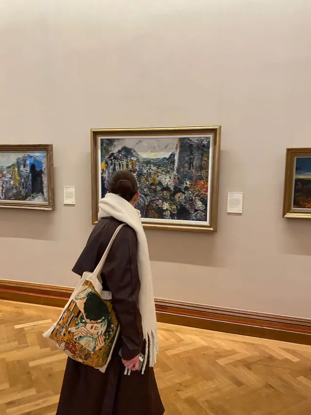 Visitante contemplando un cuadro en una sala de un museo de arte