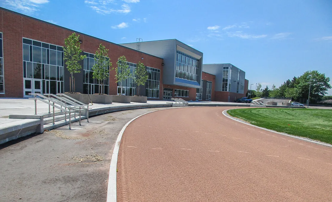 El moderno edificio de varias plantas de la Orillia Secondary School con un camino curvo y césped bien cuidado.