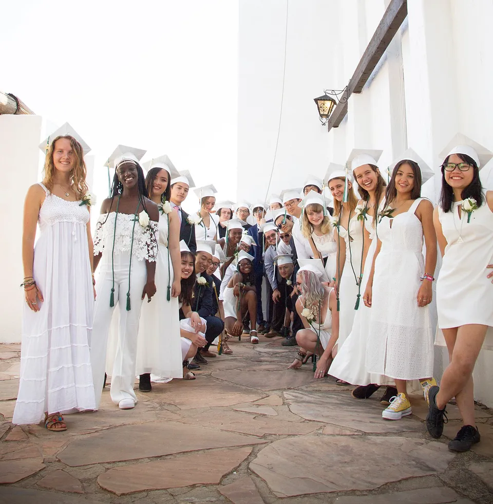 Un gruppo vario di studentesse della Verde Valley School si riunisce in uno studio luminoso con pareti bianche.