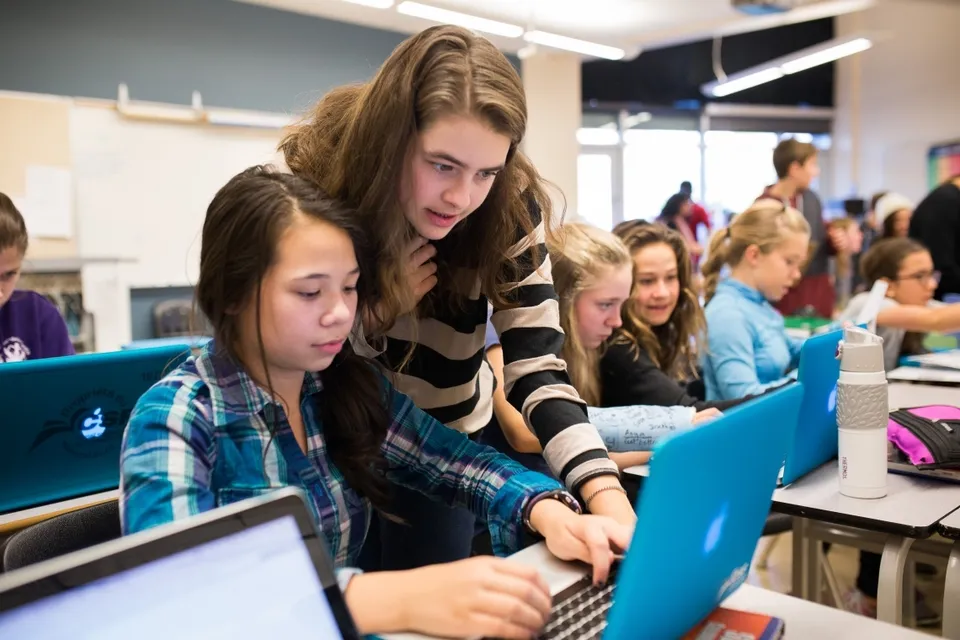 Studenti della Jules Verne School Vancouver lavorano insieme al computer in classe.