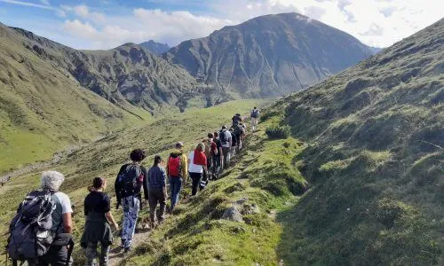 Un gruppo di studenti e studentesse fa un'escursione su un sentiero verde tra le montagne vicino al Campus La Salle Saint Christophe.