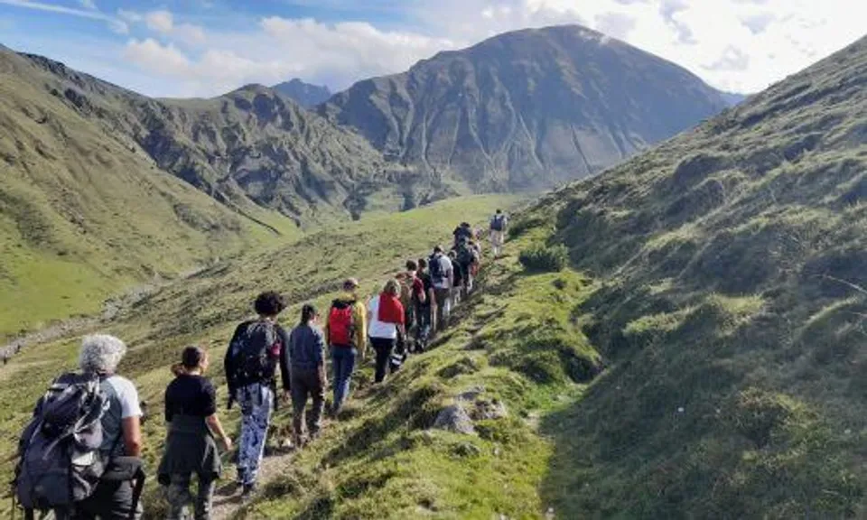 Un gruppo di studenti e studentesse fa un'escursione su un sentiero verde tra le montagne vicino al Campus La Salle Saint Christophe.