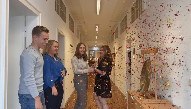 Konfettiparty im Büro mit mehreren Mitarbeiterinnen und Mitarbeitern