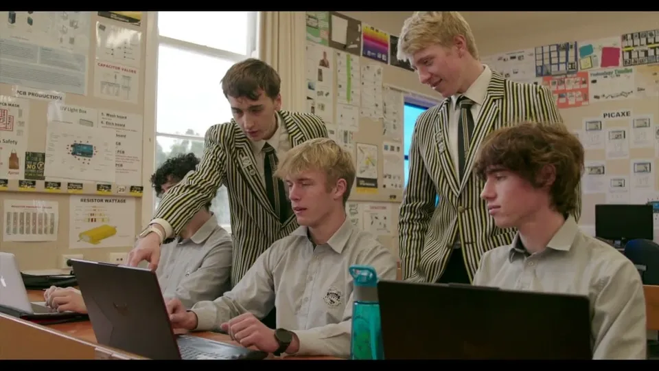 Quattro studenti della New Plymouth Boys' High School siedono a un tavolo e lavorano al computer in un'aula.