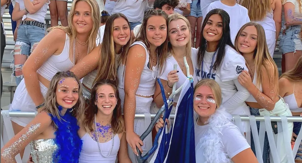 Un gruppo di studentesse del Chico Unified School District si trova all'esterno davanti a uno stadio e sorride alla fotocamera.