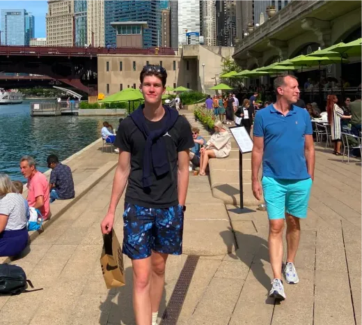 Tim cammina lungo il Riverwalk sul fiume con lo skyline di Chicago negli Stati Uniti.
