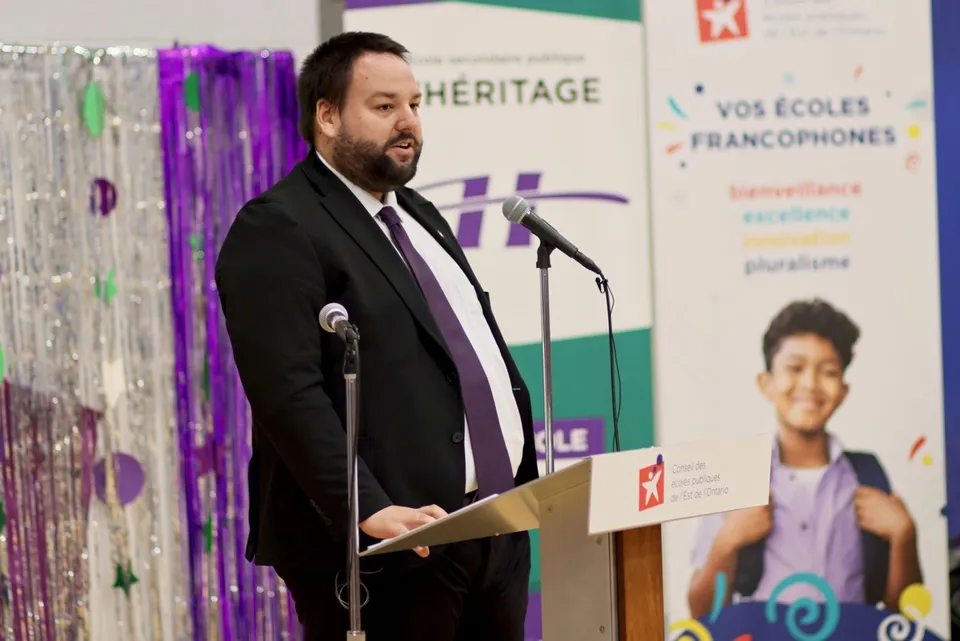 Un uomo in abito tiene un discorso al leggio durante un evento delle Eastern Ontario Public Schools.