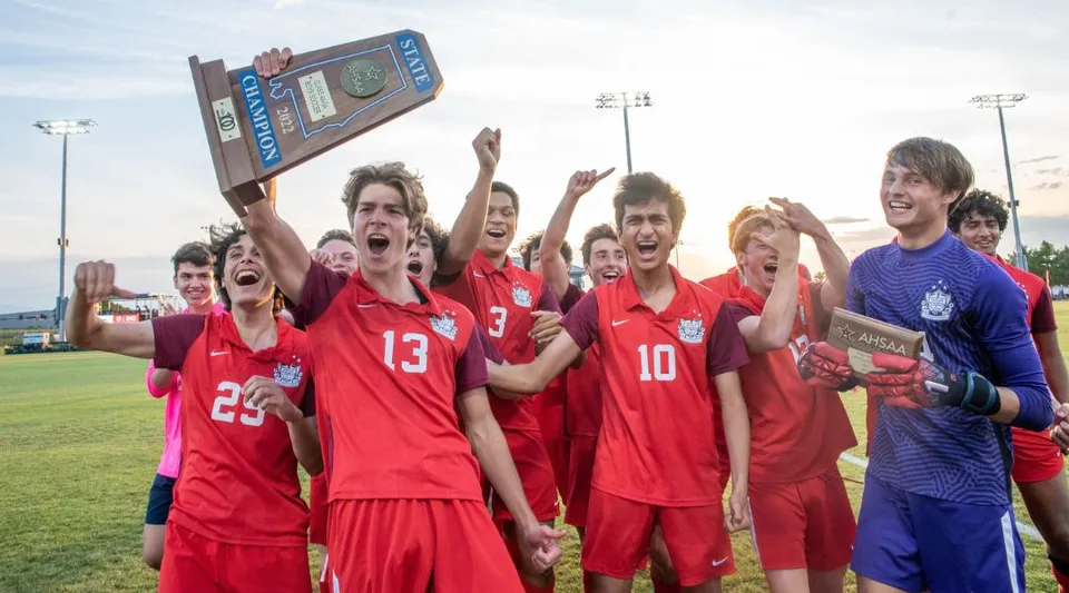 Un gruppo di studenti della Indian Springs School che gioca a calcio festeggia la vittoria davanti al tabellone segnapunti.