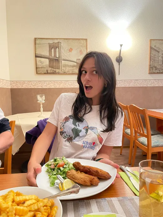 Studentessa al ristorante davanti a un piatto di cotoletta e patatine