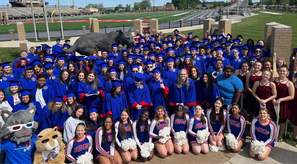 Un gruppo di studentesse e studenti della Kokomo-Center Township Consolidated School Corporation è in piedi davanti a uno stadio sportivo.