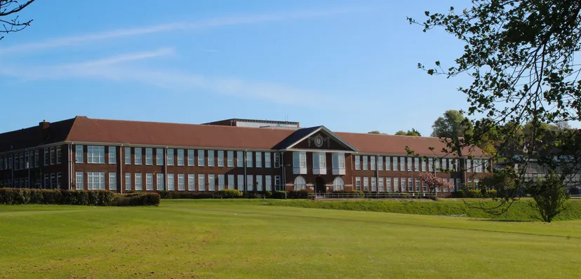 L'edificio in mattoni a più piani con tetto rosso sul prato verde del Varndean College.