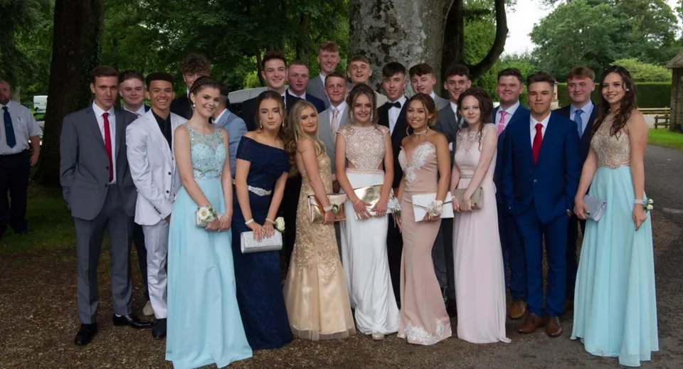 Un gruppo di studenti della Lincoln Minster School si raccoglie all'aperto davanti ad alberi e aree verdi.