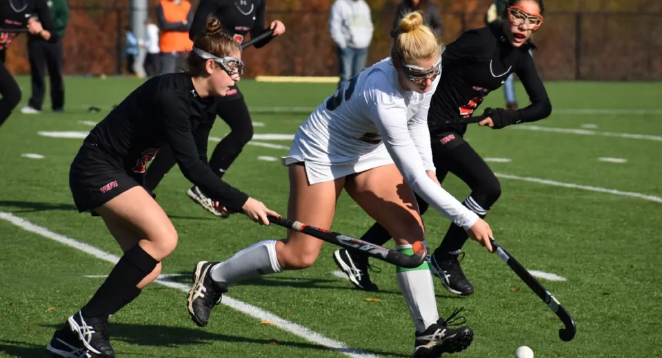Studentesse e studenti del St. Leo’s College giocano una partita di hockey su prato sul campo verde.