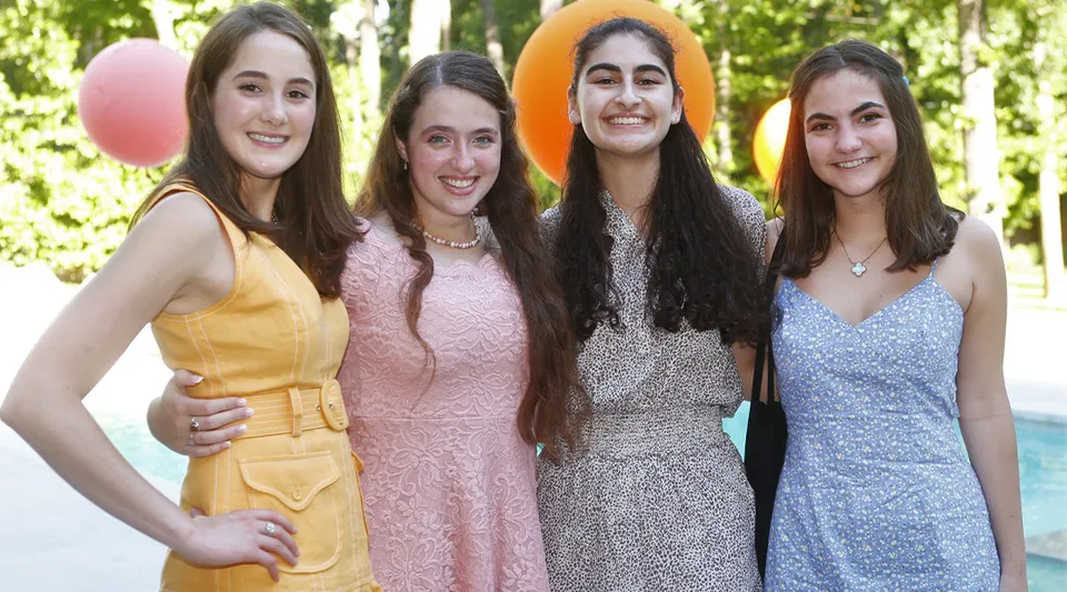 Quattro studentesse della St. John's School sono insieme in un'area verde all'aperto.