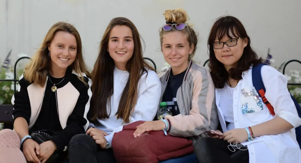 Quattro studentesse della Durham School posano insieme sorridendo in un'area esterna.