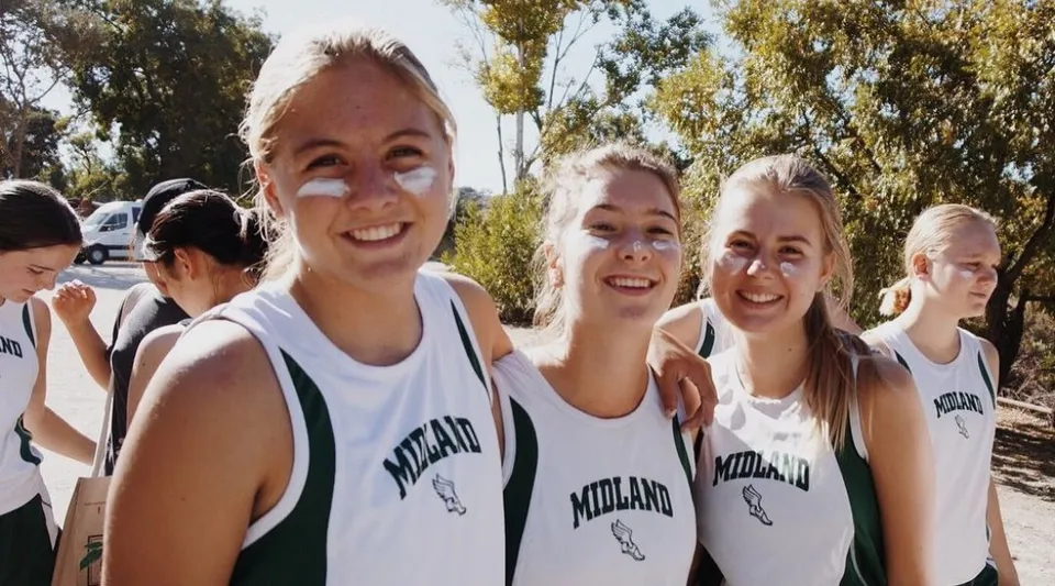 Un gruppo di studentesse della Midland School è insieme all'aperto e indossa maglie sportive abbinate.