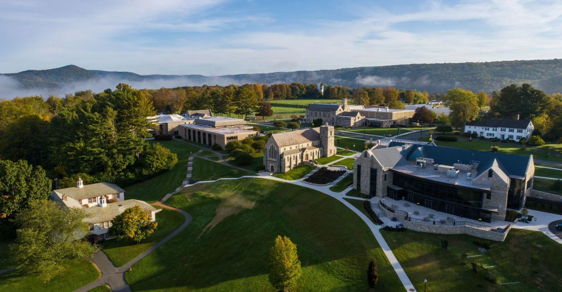 Il campus della Canterbury School con edifici storici e moderni immerso in un paesaggio collinare verde.