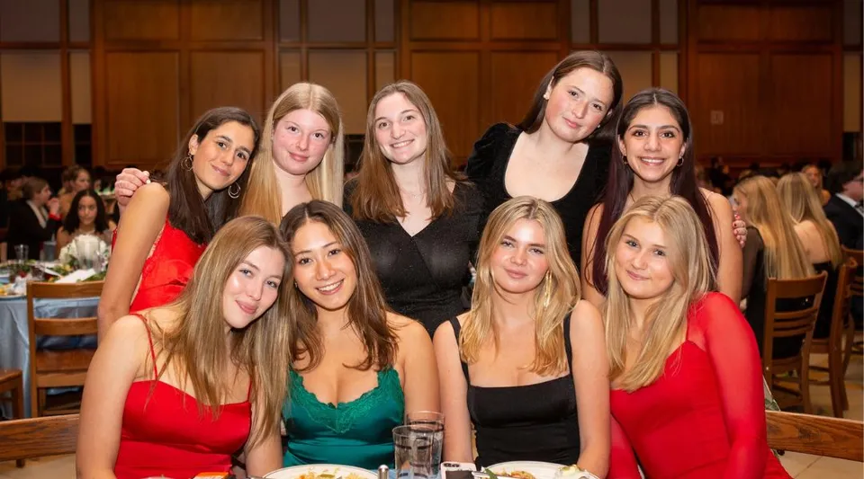 Un gruppo di giovani donne in abiti eleganti posa insieme durante un evento alla Suffield Academy.