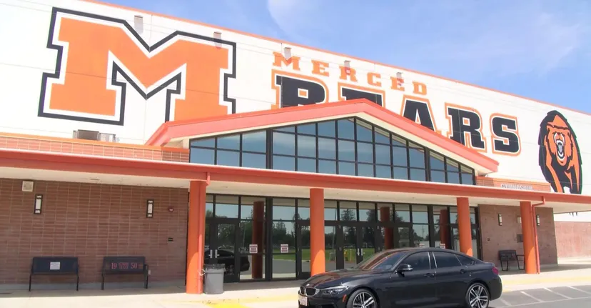 Davanti a un grande negozio con la scritta Meijer si trova una limousine nera nel parcheggio del Merced Union High School District.