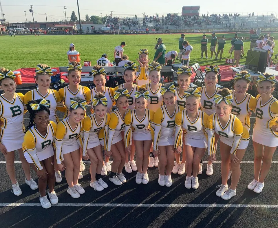 Un gruppo di giovani atlete della Bonneville High School si raduna su un campo da gioco verde.