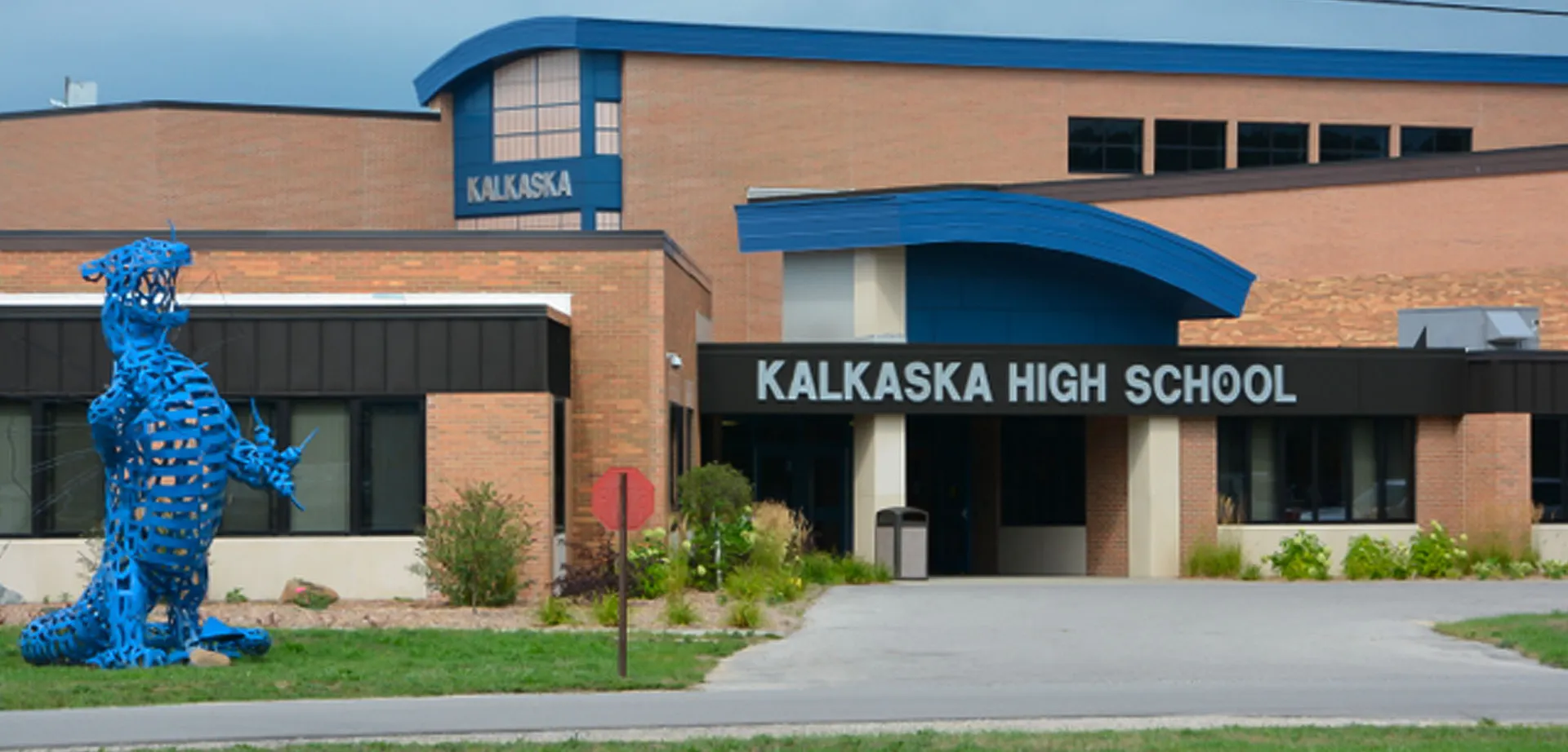 L'edificio moderno in mattoni con dettagli blu e la scritta Kalkaska High School sull'ingresso principale.