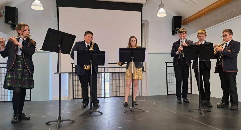 Studenti del Shebbear College sono sul palco in abito formale e presentano una rappresentazione.