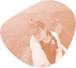 Estudiante con gorra haciéndose un selfie junto al agua
