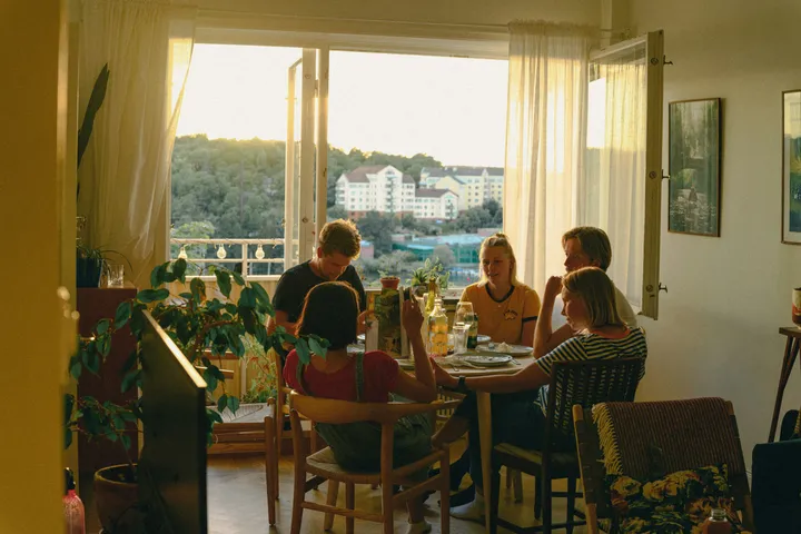Familie beim gemeinsamen Abendessen am offenen Fenster