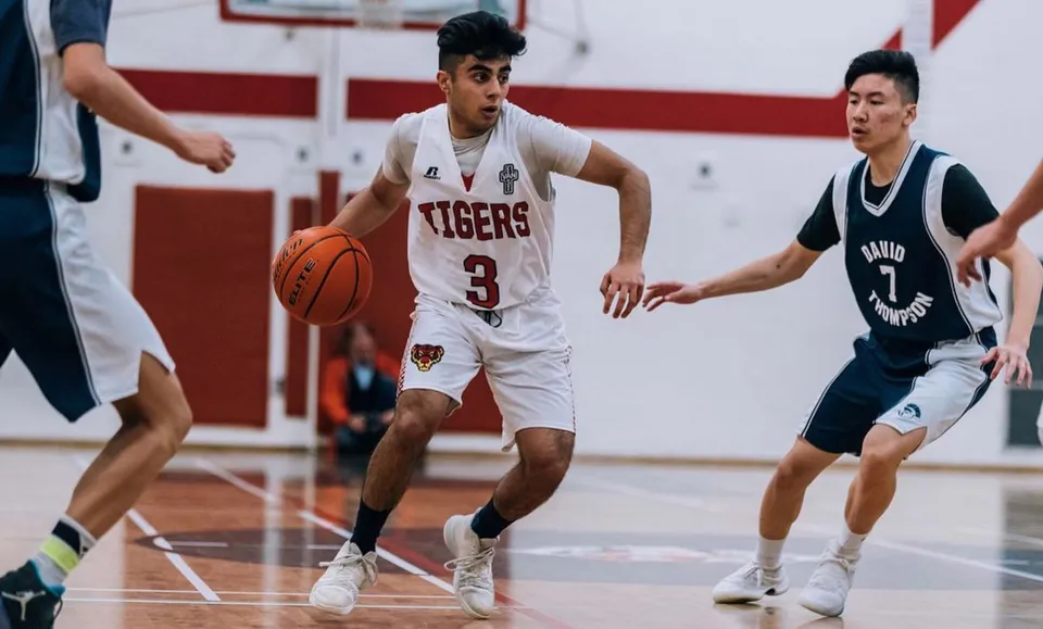 Due studenti della David Thompson Secondary School a Vancouver lottano per la palla sul campo da basket.