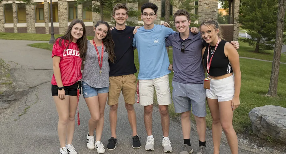 Un gruppo di studenti e studentesse si trova insieme in un'area verde del campus della Quad Cities Christian School.