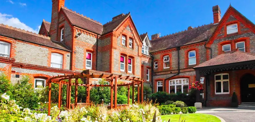 L'edificio in mattoni della St. George's Ascot è circondato da un giardino curato con una vegetazione lussureggiante.
