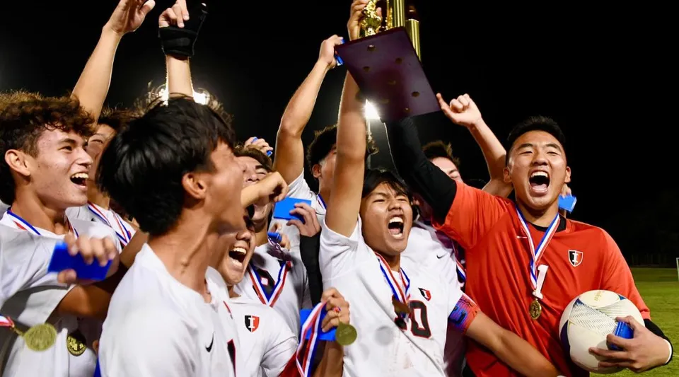 Studenti della Iolani School festeggiano insieme la loro vittoria davanti a uno stadio.