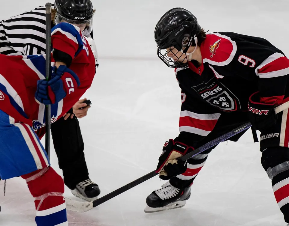 Due giocatori di hockey della Bishop Kearney High School si affrontano sul ghiaccio incrociando i bastoni.