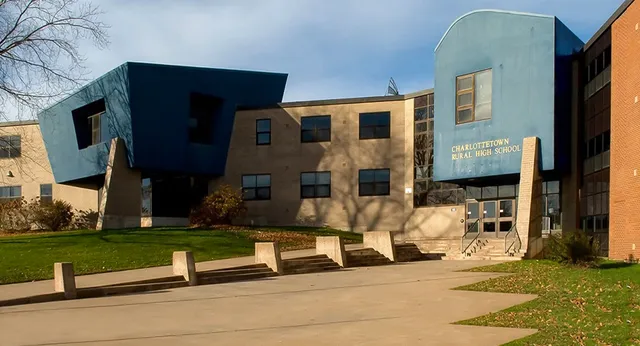 Das moderne Gebäude der Charlottetown Rural High School steht in einer Grünfläche mit Gehwegen zum Eingang.