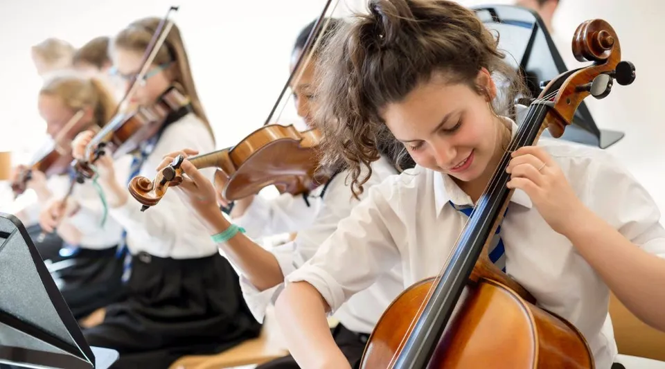 Un gruppo di giovani musicisti suona i violini durante una lezione alla St. Mary’s Music School.