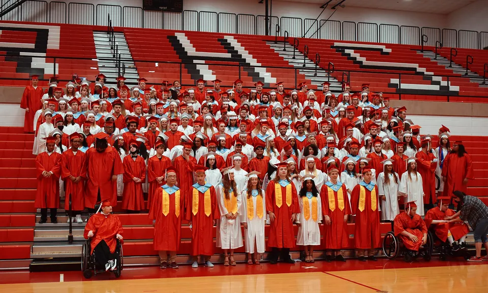 Un grande gruppo di studenti della Richmond High School si riunisce in palestra per la cerimonia di diploma.