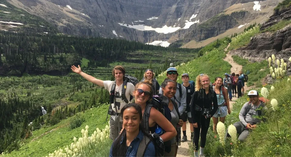 Un gruppo di studenti della Sugarloaf Senior High cammina su un sentiero in un paesaggio montuoso.