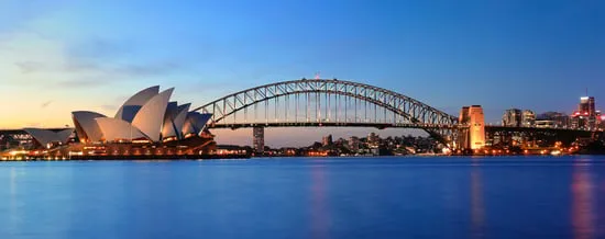 Opernhaus von Sydney und Harbour Bridge in der Abenddämmerung über dem Hafen