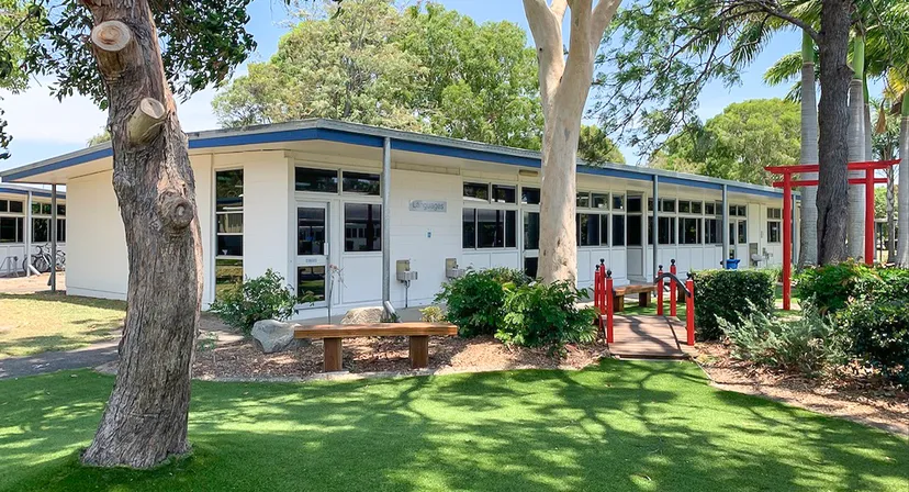 L'edificio moderno ad un piano nel campus del Kawana Waters State College è circondato da aree verdi e grandi alberi.